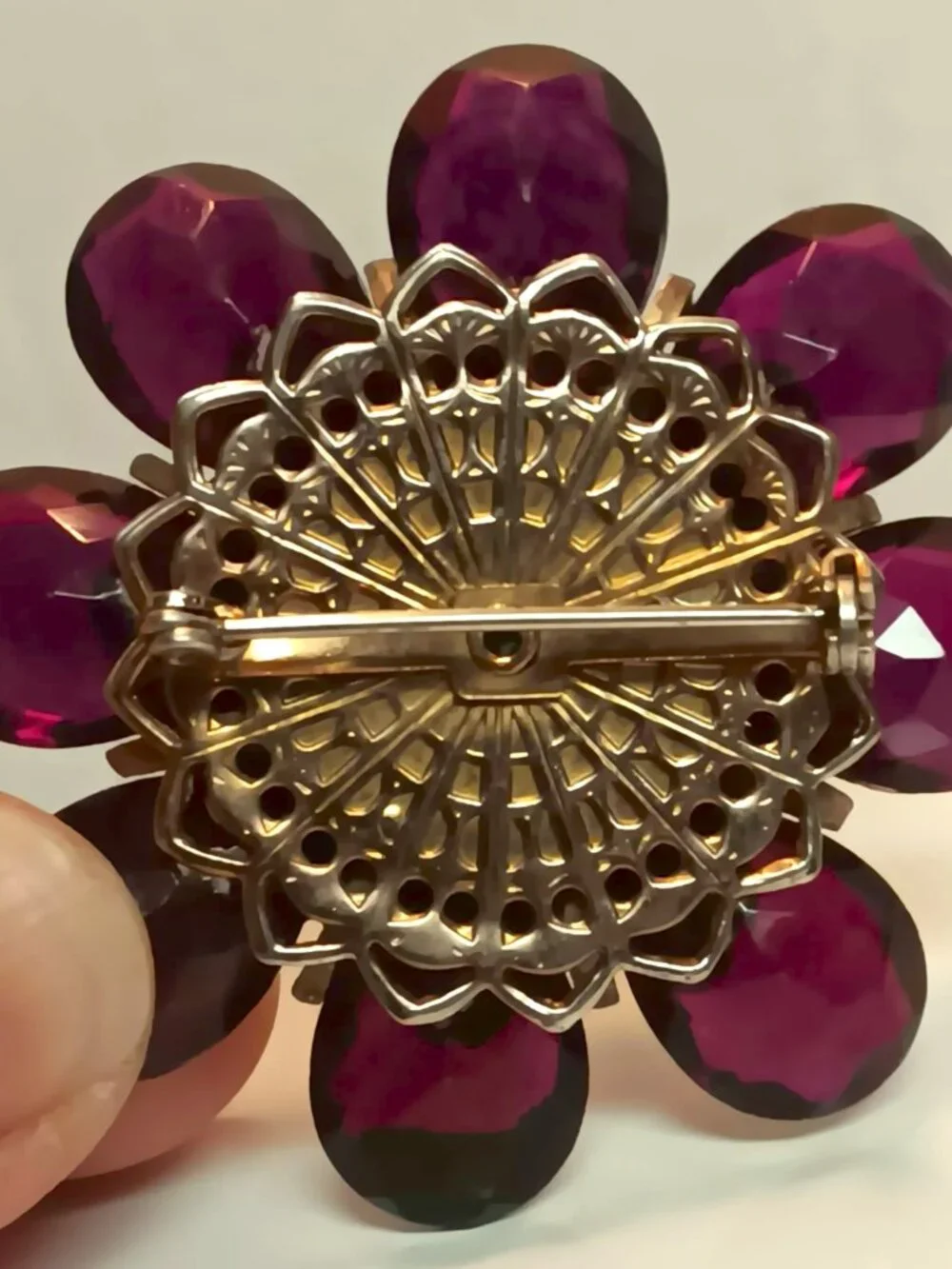 Vintage ruby lucite brooch with aurora borealis central rhinestone.